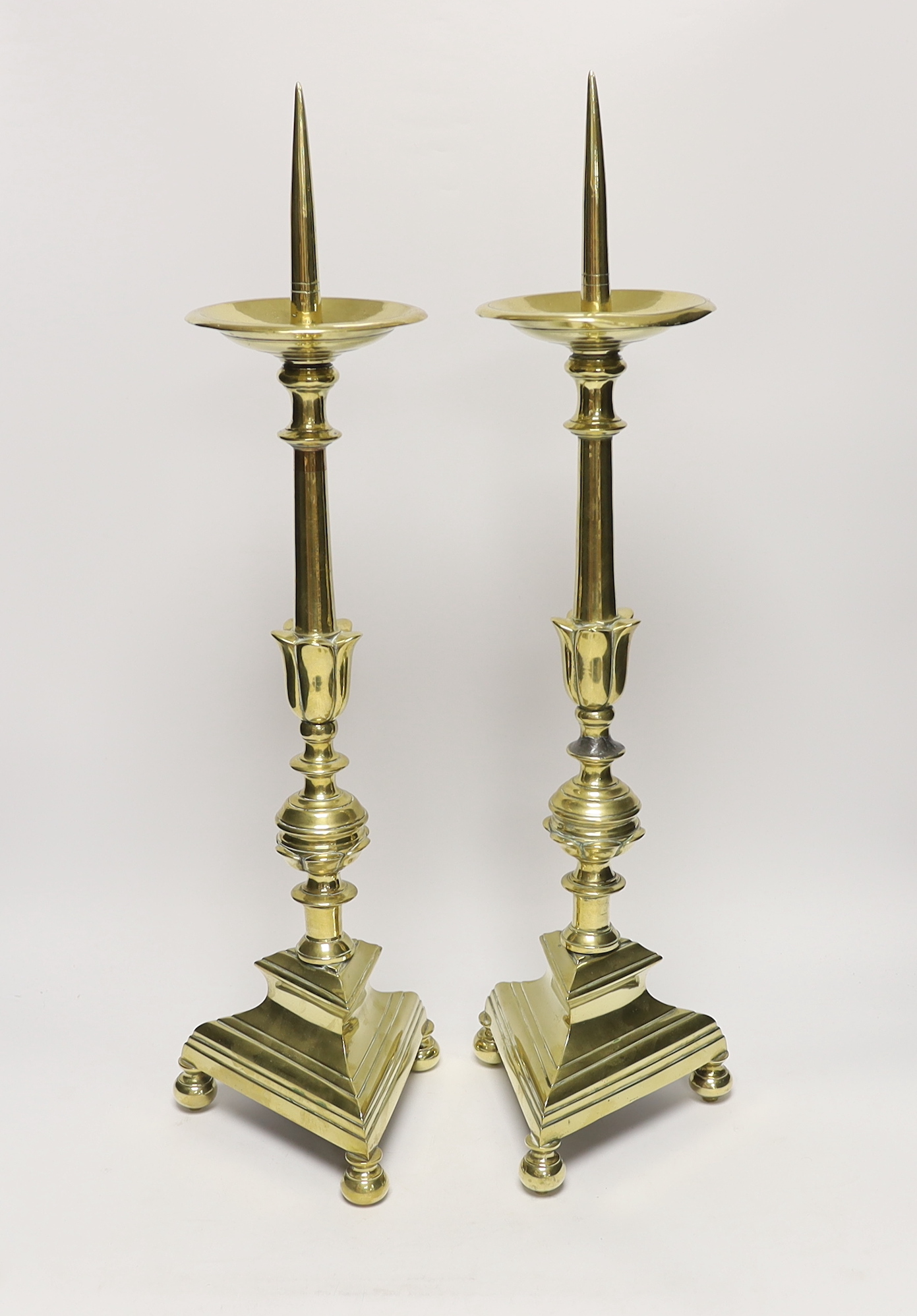 A pair of 17th Century Dutch brass pricket candlesticks, 58cm high